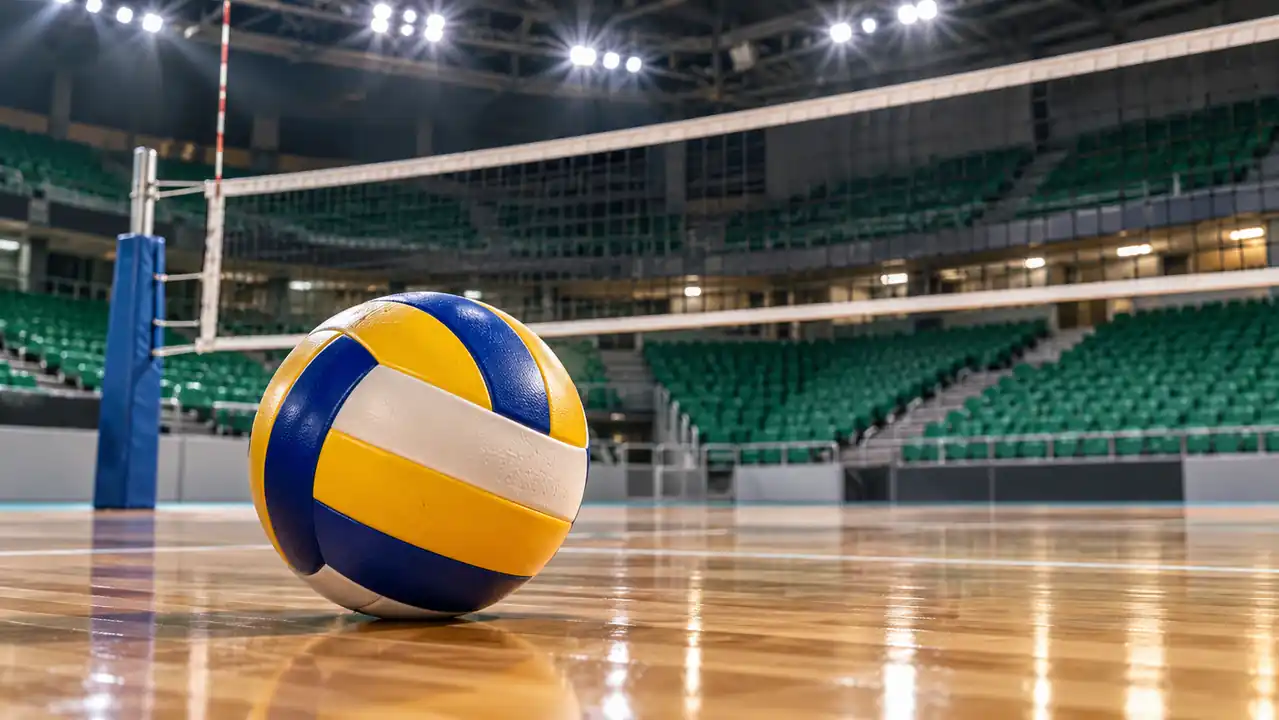 Volleyball on the wooden floor of an empty indoor arena, near the net